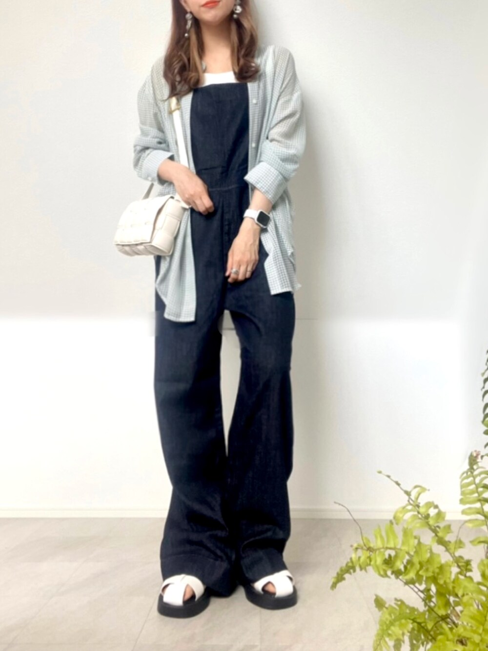 ブルー系のサロペット/オーバーオール、ホワイト系のショルダーバッグ、ホワイト系のサンダルを着用したレディースの春コーディネートの1枚目の写真