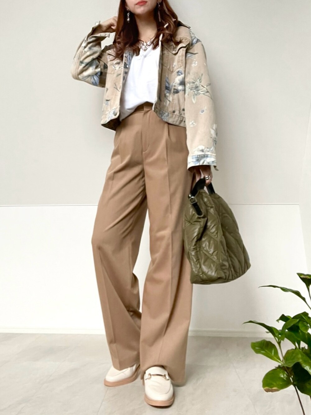 グリーン系のボストンバッグ、ベージュ系のデニムジャケット、ベージュ系のパンツを着用したレディースの冬コーディネートの1枚目の写真