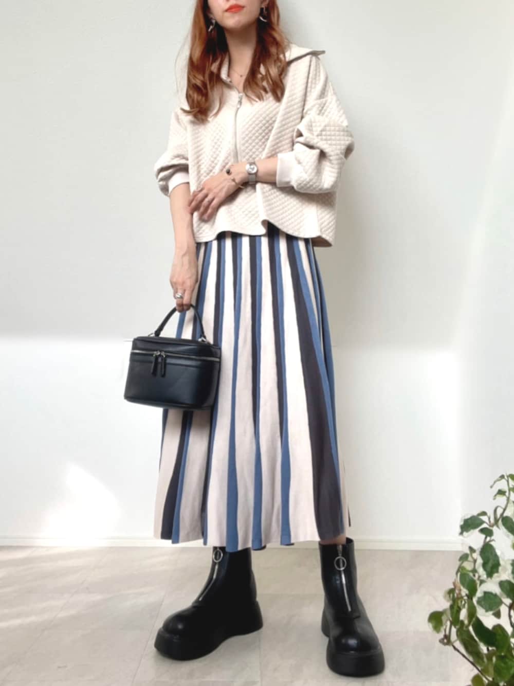 ホワイト系のその他トップス、ベージュ系のスカート、ブラック系のハンドバッグを着用したレディースの秋コーディネートの1枚目の写真