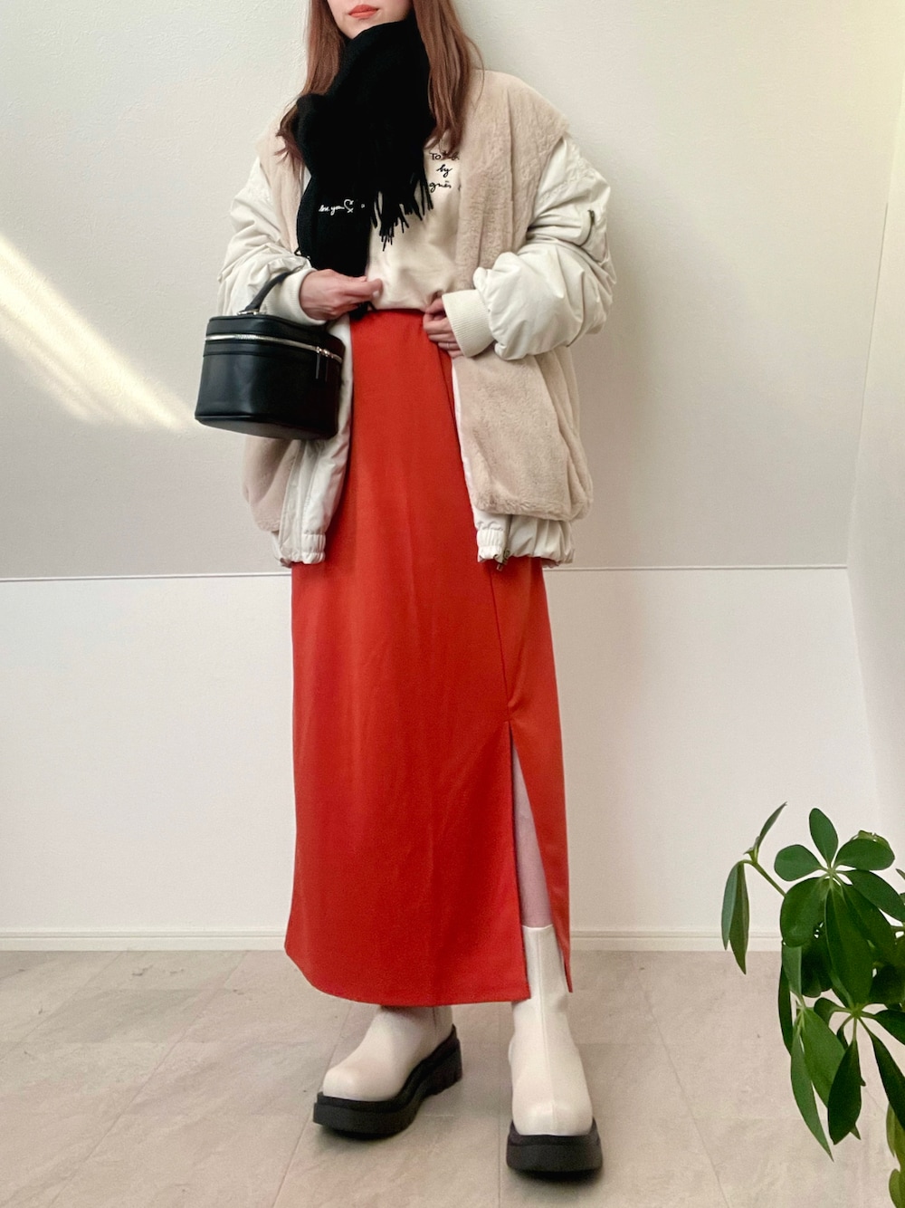 ホワイト系のブルゾン、ホワイト系のスウェット、オレンジ系のスカートを着用したレディースの冬コーディネートの1枚目の写真