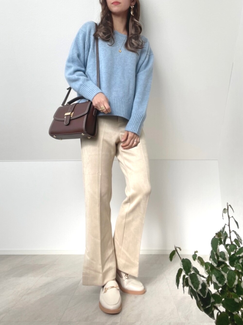 ブルー系のニット/セーター、ホワイト系のその他パンツ、ホワイト系のローファーを着用したレディースの冬コーディネートの1枚目の写真