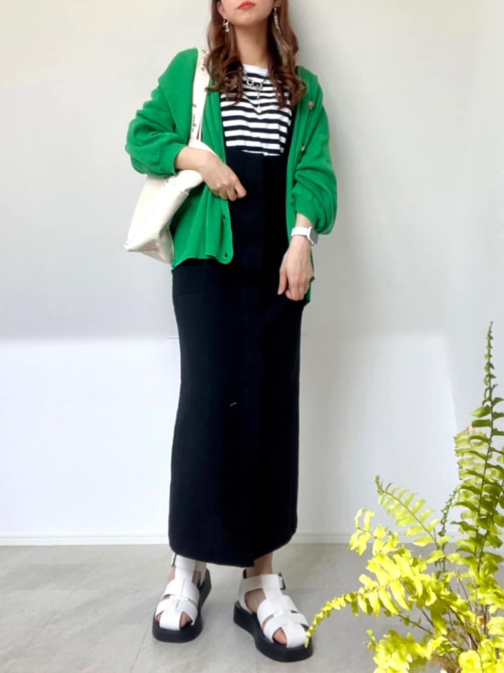 ブラック系のTシャツ/カットソー、ブラック系のジャンパースカート、ベージュ系のトートバッグを着用したレディースの春コーディネートの1枚目の写真