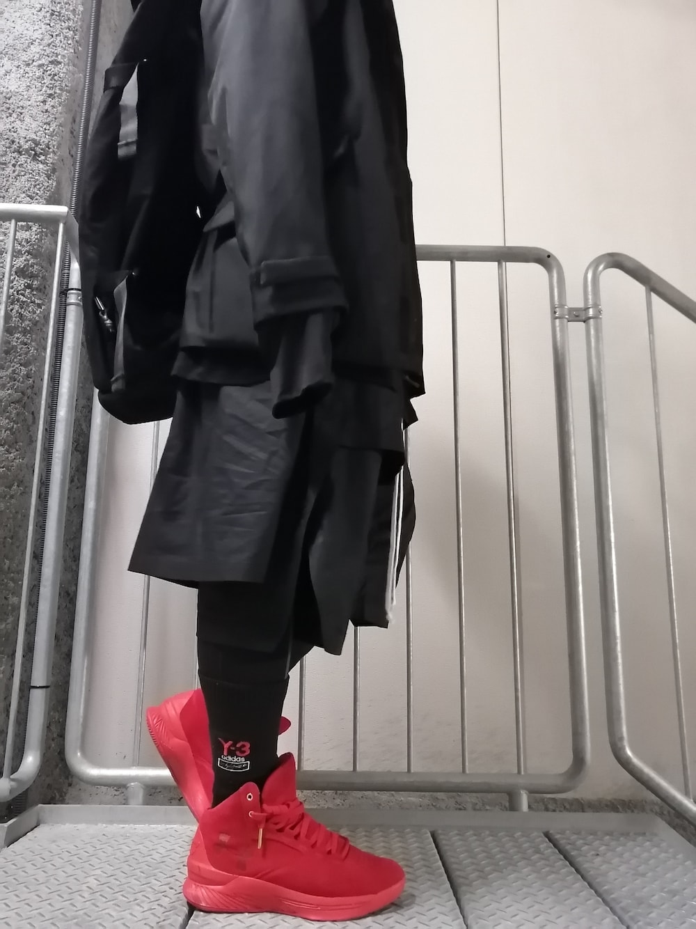 レッド系のスニーカー、ブラック系のパンツ、ブラック系のジャケット/アウターを着用したメンズの春コーディネートの1枚目の写真