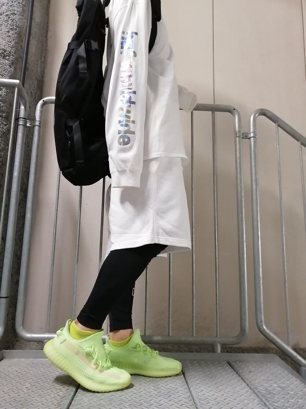 グリーン系のスニーカー、ホワイト系のパンツ、ホワイト系のトップスを着用したメンズの春コーディネートの1枚目の写真