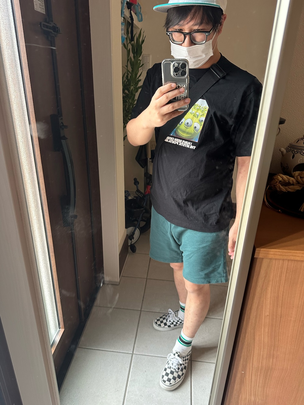 ブラック系のTシャツ/カットソー、グリーン系のパンツ、その他のスニーカーを着用したメンズの秋コーディネートの1枚目の写真