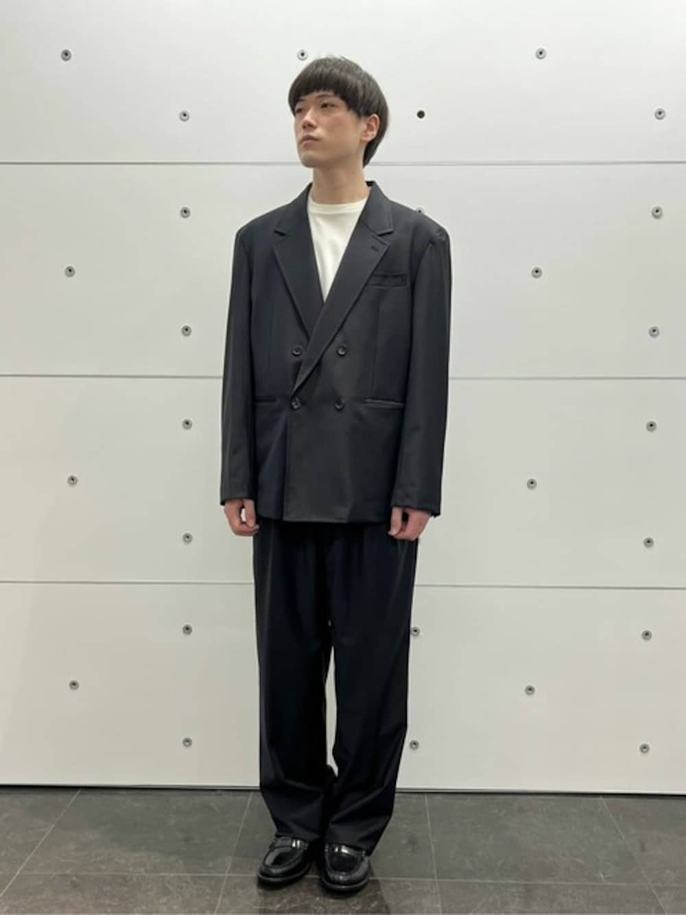 ブラック系のスーツジャケット、ブラック系のスーツパンツを着用したメンズの春コーディネートの1枚目の写真