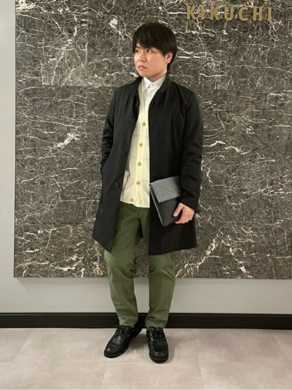 「カーディガン、シャツ、クラッチバッグ、ショルダーバッグ、ベイカーパンツ、デッキシューズ、タケオキクチ(TAKEO KIKUCHI)、スタンドカラー、スプリングコート、TAKEO KIKUCHI」｜「TAKEO KIKUCHIの【オンオフ兼用】耐久撥水 スタンドカラー コート（その他アウター、ブラック系）」を使った、TAKEO KIKUCHIさん（メンズ・165cm）の春コーディネートの1枚目の写真