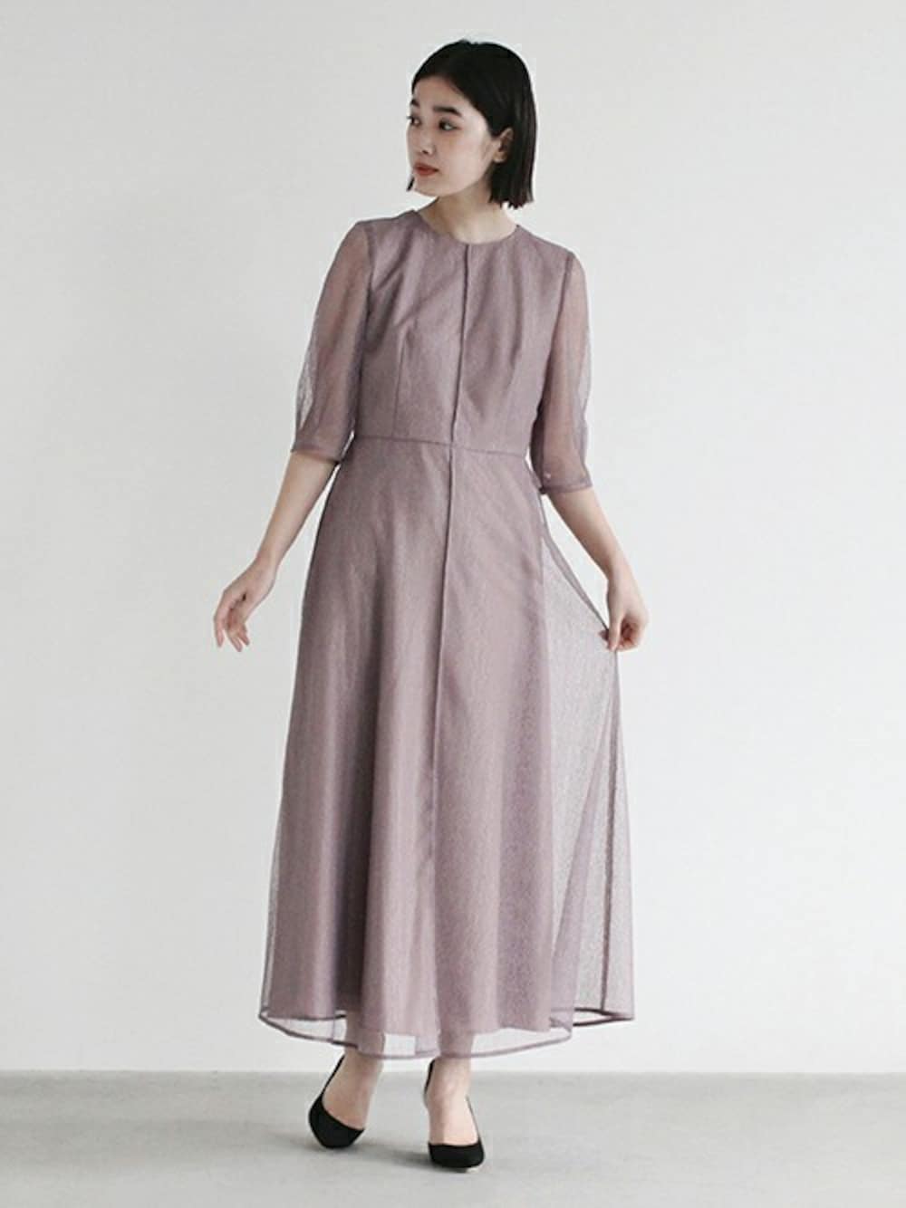 パープル系のドレスを着用したレディースの冬コーディネートの1枚目の写真