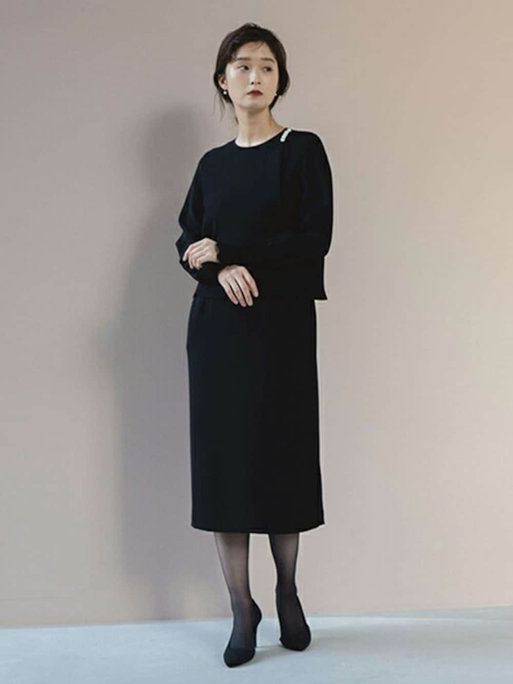 ブラック系のドレスを着用したレディースの冬コーディネートの1枚目の写真