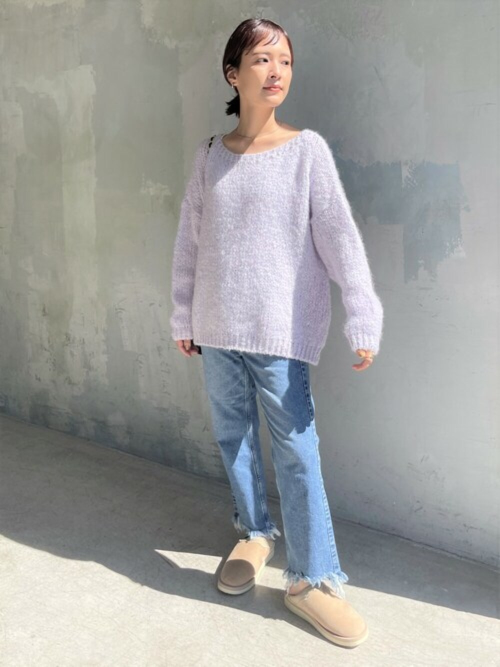 ベージュ系のスリッポン、ブルー系のデニムパンツ、パープル系のニット/セーターを着用したレディースの秋コーディネートの1枚目の写真