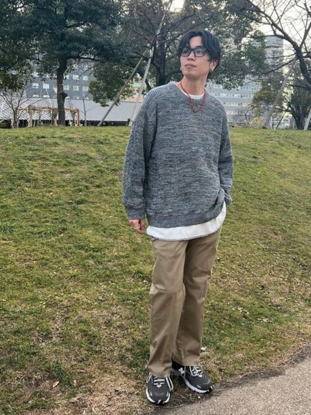 ブルー系のニット/セーター、ホワイト系のTシャツ/カットソー、ベージュ系のチノパンツを着用したメンズの冬コーディネートの1枚目の写真