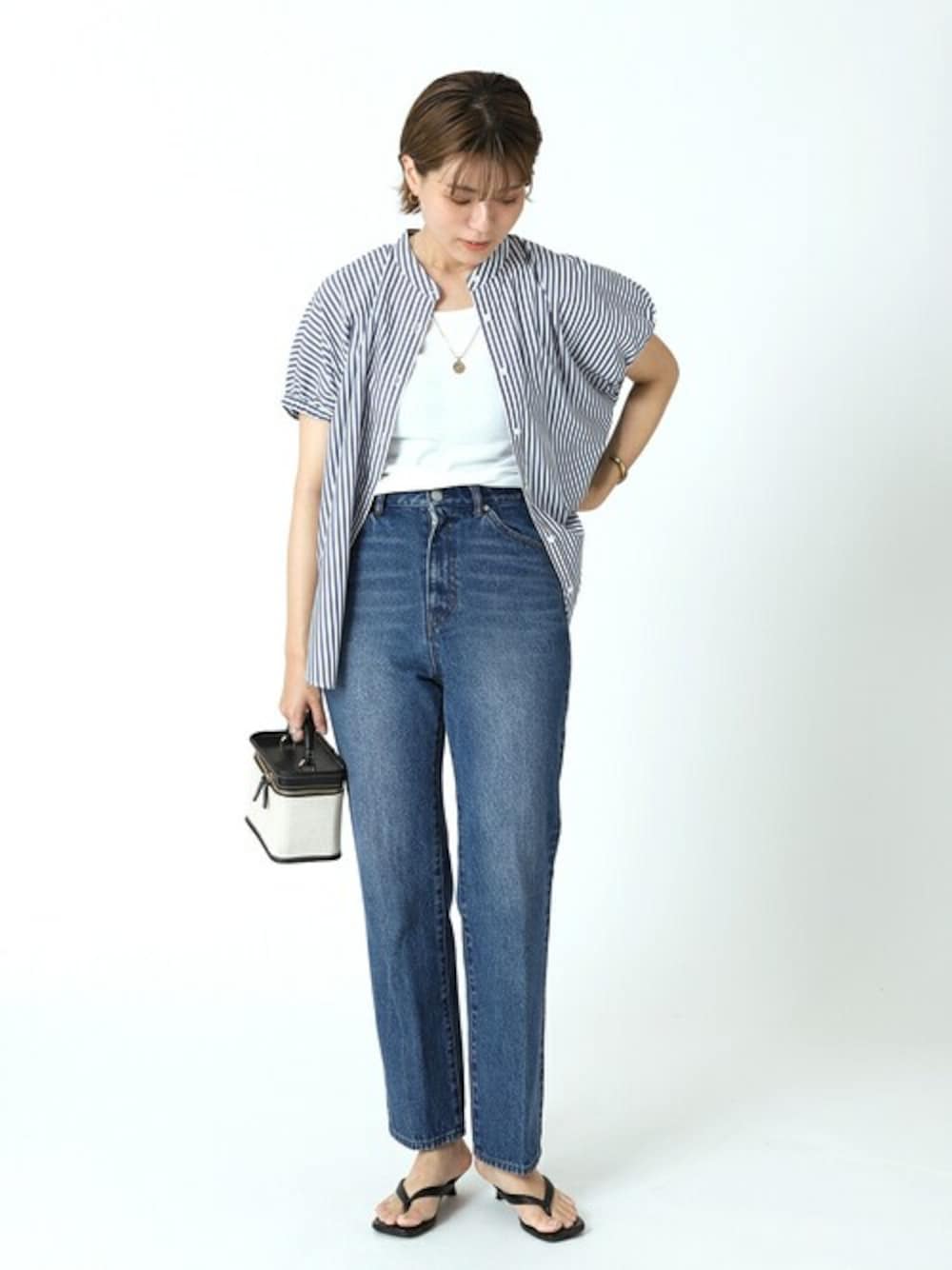 ホワイト系のTシャツ/カットソー、ブラック系のショルダーバッグ、ブラック系のサンダルを着用したレディースの夏コーディネートの1枚目の写真