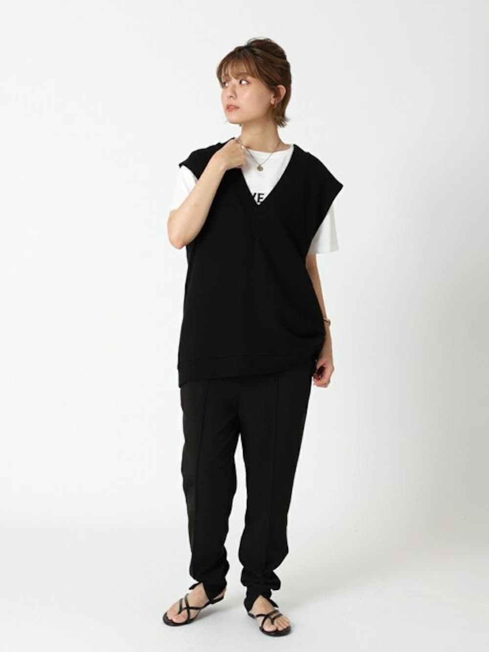 ブラック系のスラックス、ホワイト系のTシャツ/カットソー、ブラック系のベストを着用したレディースの夏コーディネートの1枚目の写真