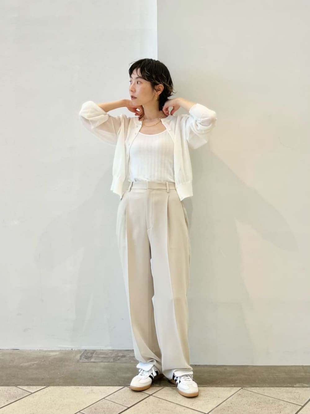ホワイト系のスラックス、ホワイト系のカーディガン/ボレロ、ホワイト系のタンクトップを着用したレディースの夏コーディネートの1枚目の写真