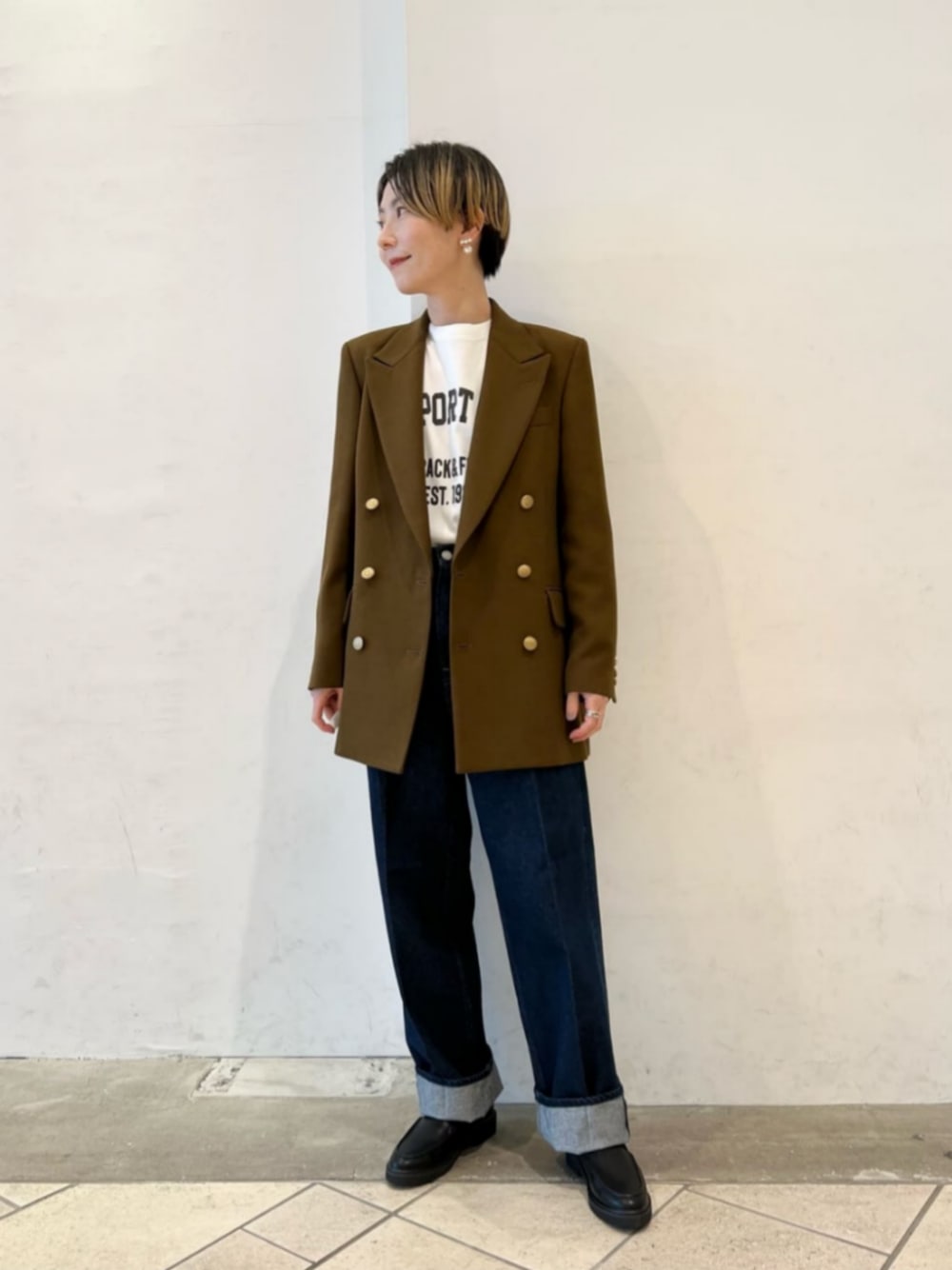 ブラウン系のテーラードジャケット、ホワイト系のTシャツ/カットソー、ブルー系のデニムパンツを着用したレディースの秋コーディネートの1枚目の写真