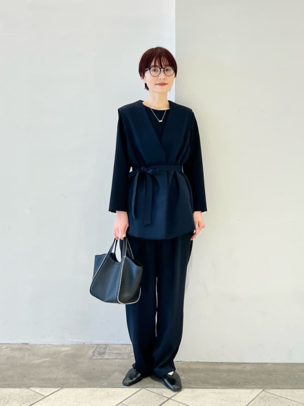 ブラック系のパンプス、ブラック系のショルダーバッグ、ブルー系のその他アウターを着用したレディースの冬コーディネートの1枚目の写真