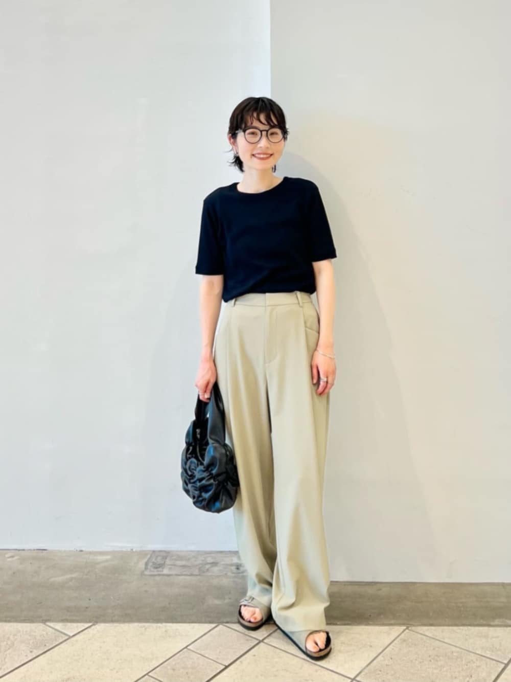 ブラック系のTシャツ/カットソー、グリーン系のその他パンツ、ブラック系のショルダーバッグを着用したレディースの夏コーディネートの1枚目の写真