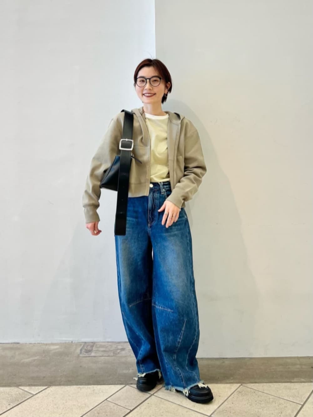 ブラック系のショルダーバッグ、グリーン系のパーカー、グリーン系のTシャツ/カットソーを着用したレディースの春コーディネートの1枚目の写真