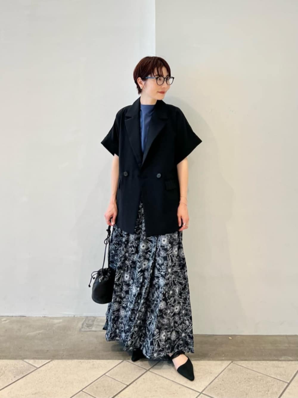 ブラック系のテーラードジャケット、ブルー系のTシャツ/カットソー、ブラック系のスカートを着用したレディースの秋コーディネートの1枚目の写真