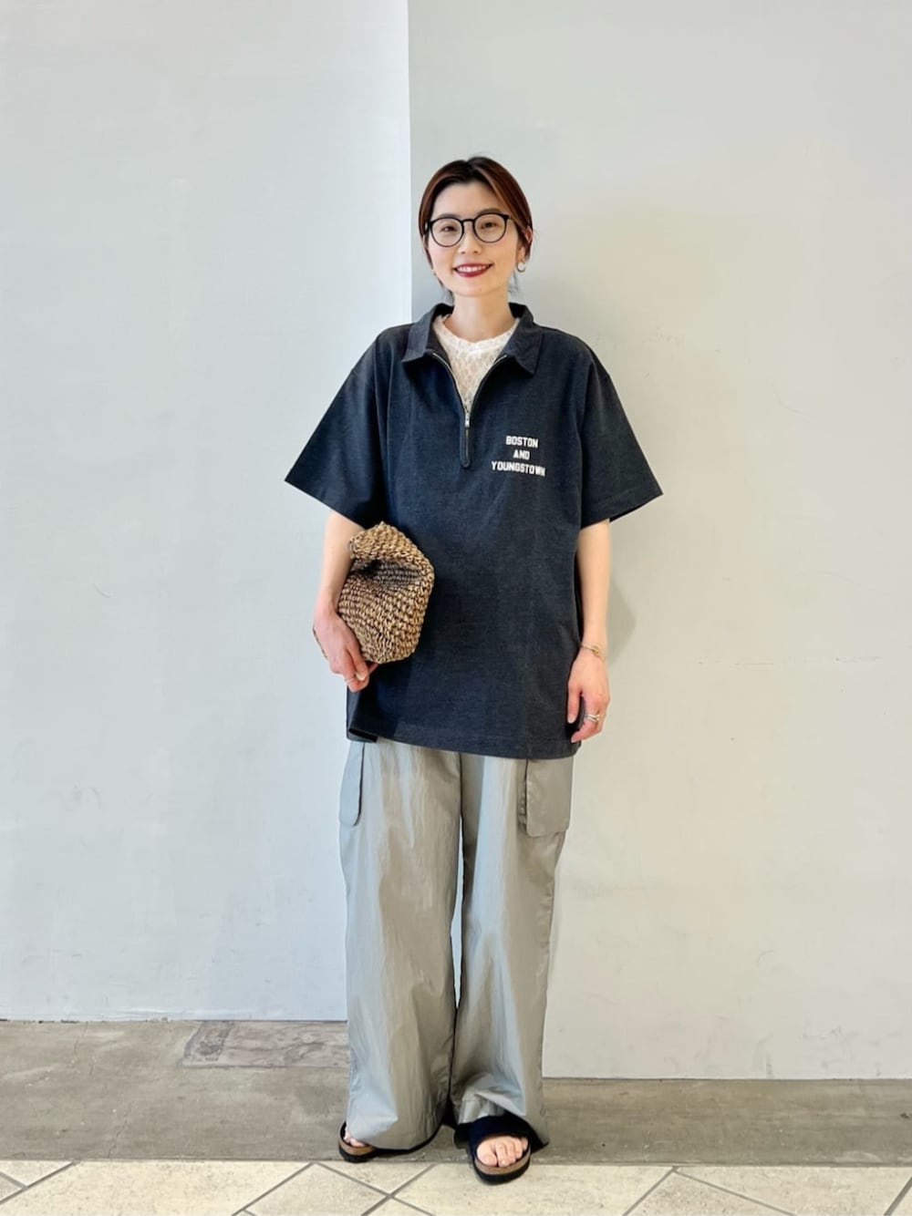グレー系のポロシャツ、ホワイト系のTシャツ/カットソー、グレー系のカーゴパンツを着用したレディースの夏コーディネートの1枚目の写真