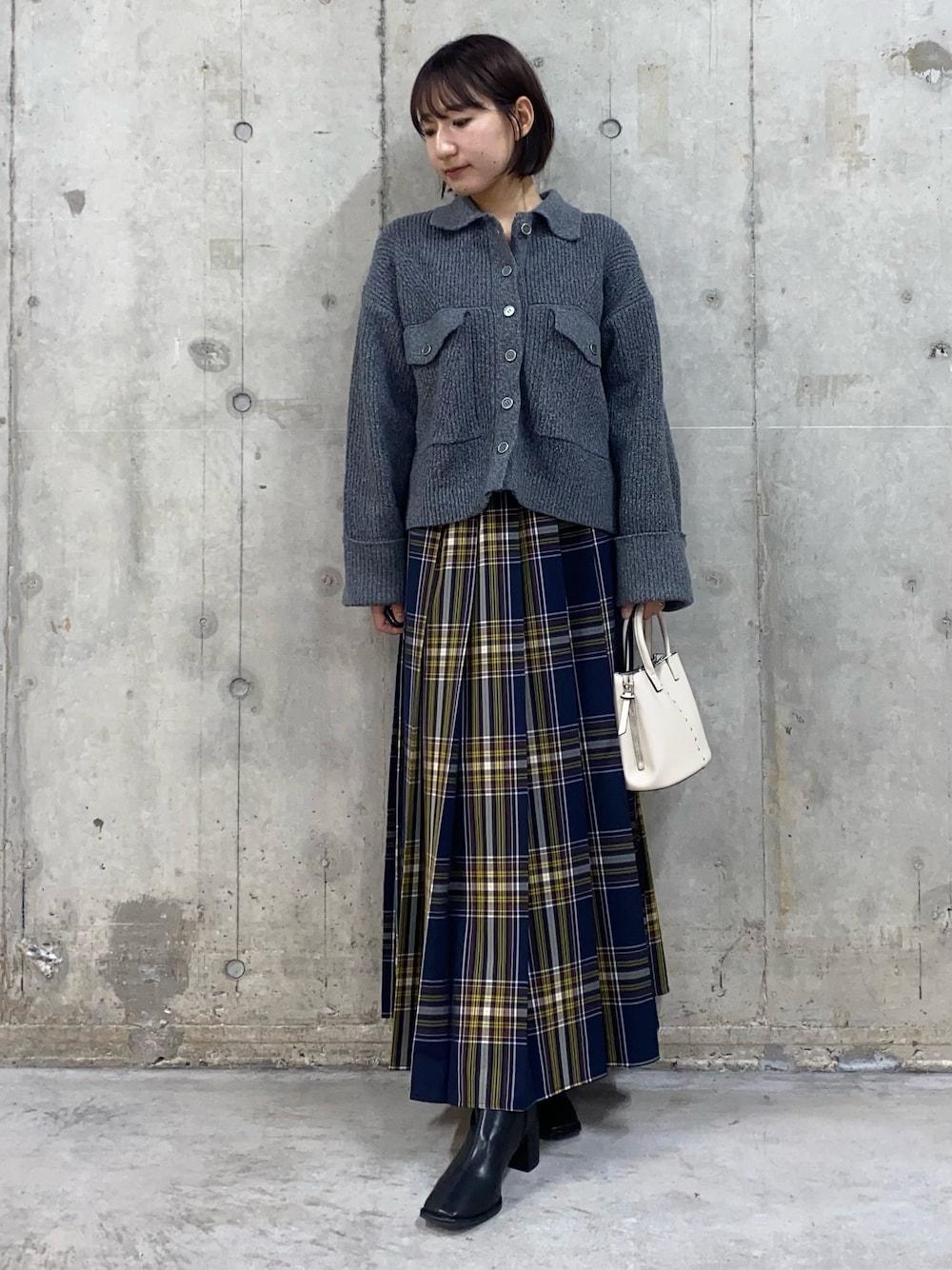 その他のスカート、グレー系のその他アウター、ブラック系のブーツを着用したレディースの秋コーディネートの1枚目の写真