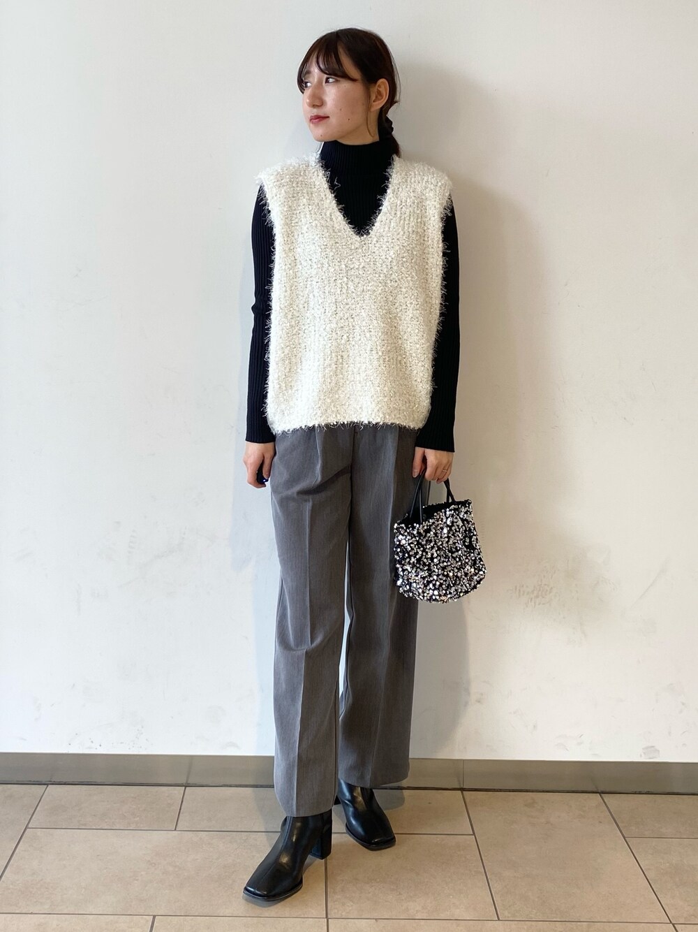 ブラック系のブーツ、グレー系のその他パンツ、シルバー系のショルダーバッグを着用したレディースの冬コーディネートの1枚目の写真