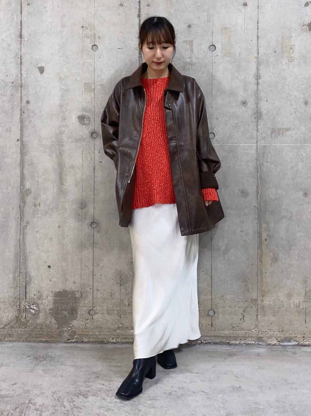 ブラウン系のその他アウター、レッド系のニット/セーター、ホワイト系のスカートを着用したレディースの秋コーディネートの1枚目の写真