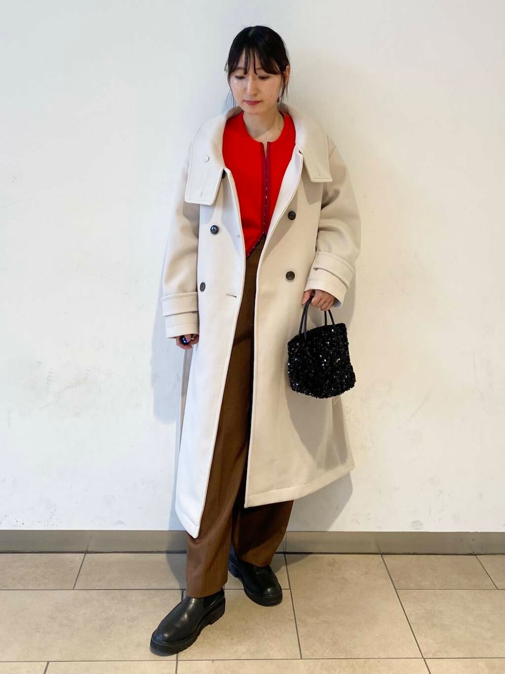 ブラック系のショルダーバッグ、ブラック系のブーツ、ベージュ系のその他アウターを着用したレディースの冬コーディネートの1枚目の写真