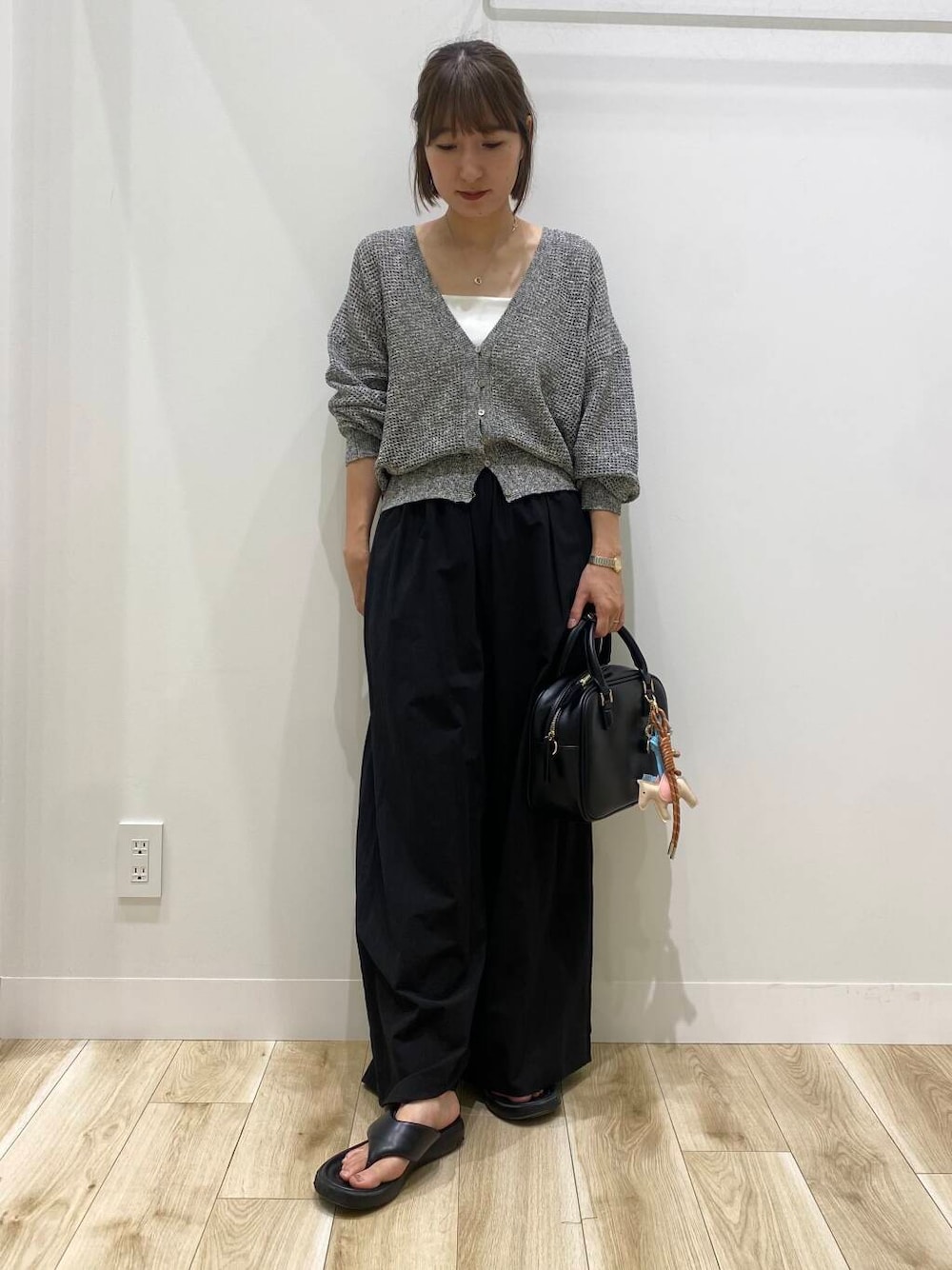 ブラック系のその他パンツ、ブラック系のボストンバッグ、ブラック系のカーディガン/ボレロを着用したレディースの夏コーディネートの1枚目の写真