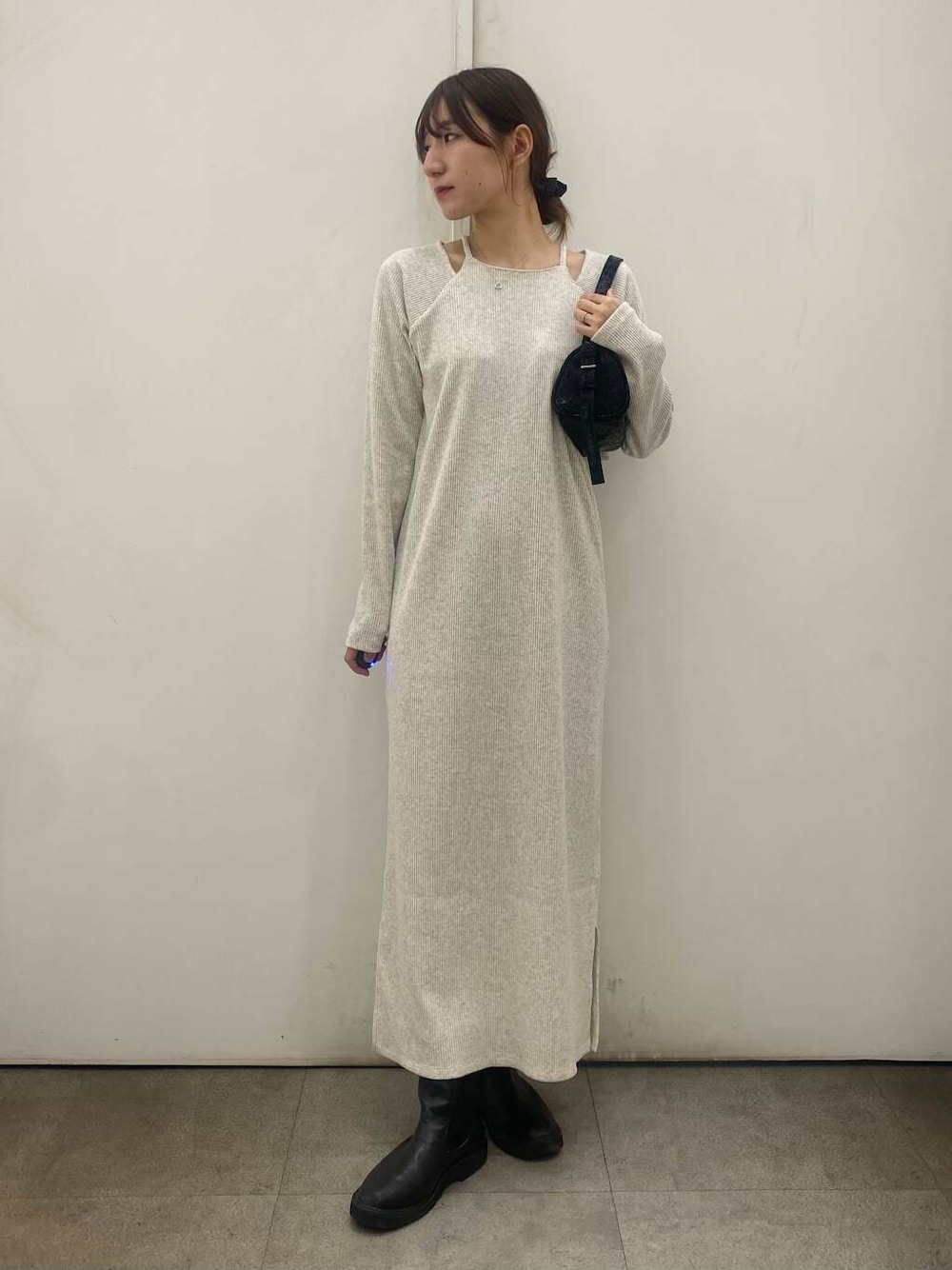 ブラック系のブーツ、ベージュ系のワンピース、ブラック系のハンドバッグを着用したレディースの冬コーディネートの1枚目の写真