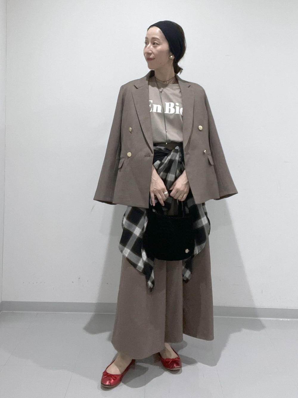 ベージュ系のスカート、ベージュ系のテーラードジャケット、ブラック系のシャツ/ブラウスを着用したレディースの夏コーディネートの1枚目の写真