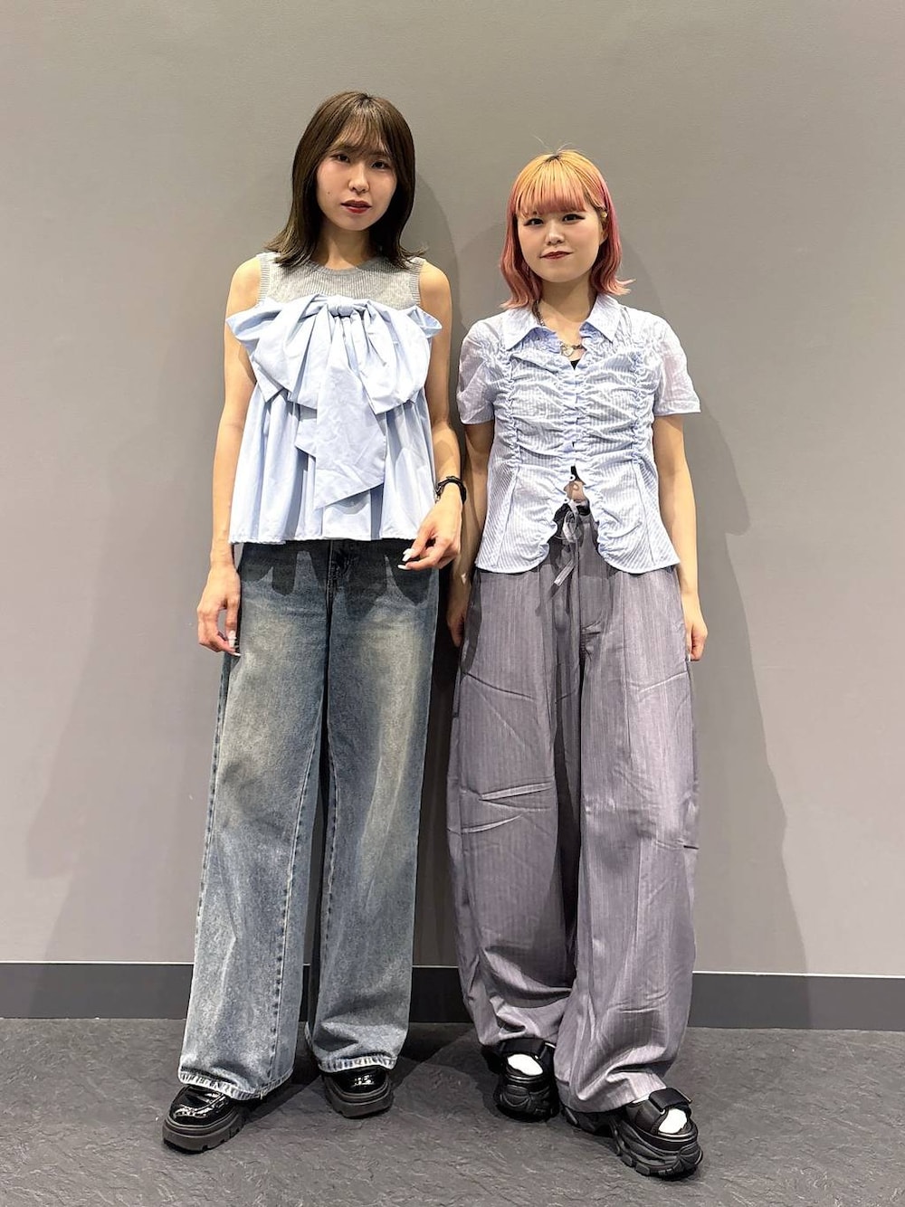 ブルー系のデニムパンツ、ブラック系のサンダル、グレー系のスラックスを着用したレディースの春コーディネートの1枚目の写真