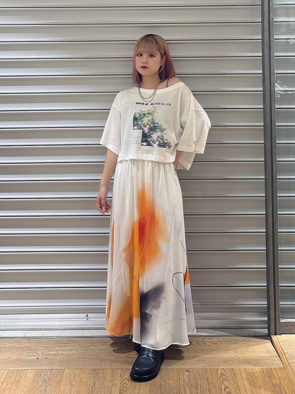 ホワイト系のスカート、ブラック系のローファー、ホワイト系のTシャツ/カットソーを着用したレディースの夏コーディネートの1枚目の写真