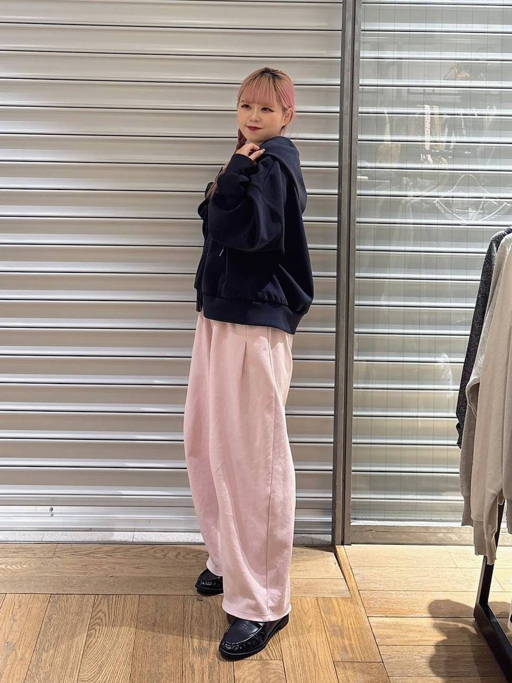 ブルー系のパーカー、ブラック系のローファー、ピンク系のスウェットパンツを着用したレディースの冬コーディネートの1枚目の写真