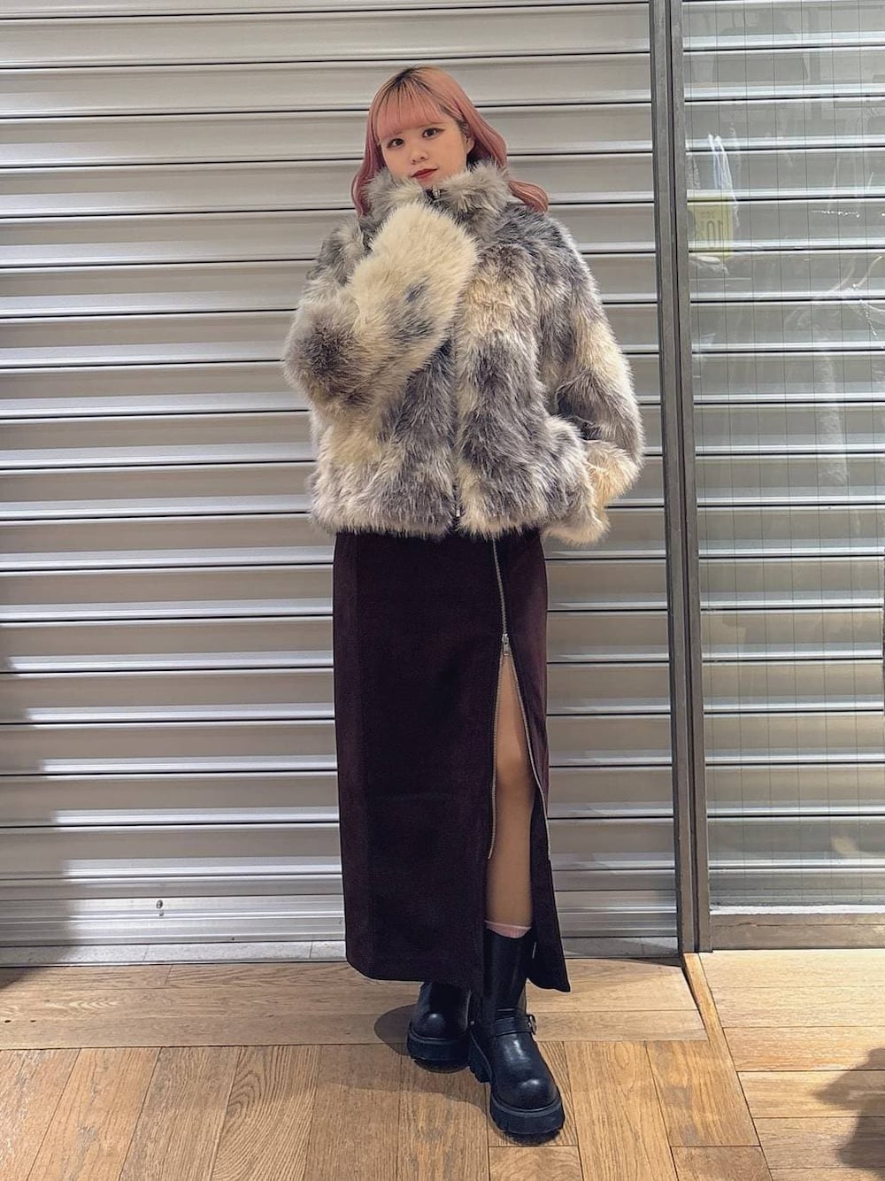 ブラウン系のスカート、グレー系のブルゾン、ブラック系のブーツを着用したレディースの冬コーディネートの1枚目の写真