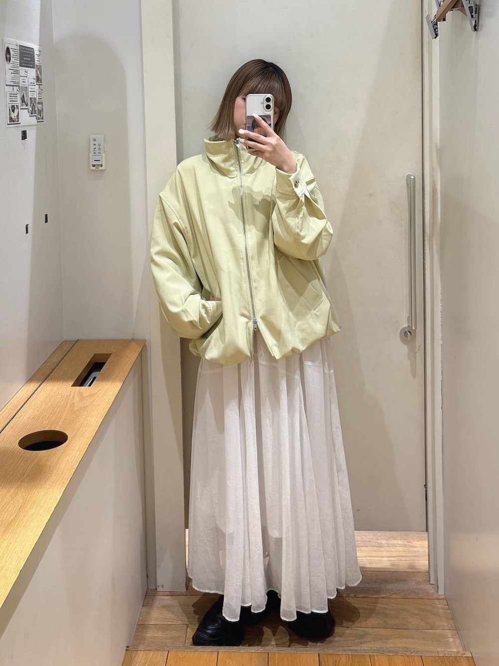 ブラック系のローファー、イエロー系のブルゾン、ホワイト系のスカートを着用したレディースの春コーディネートの1枚目の写真