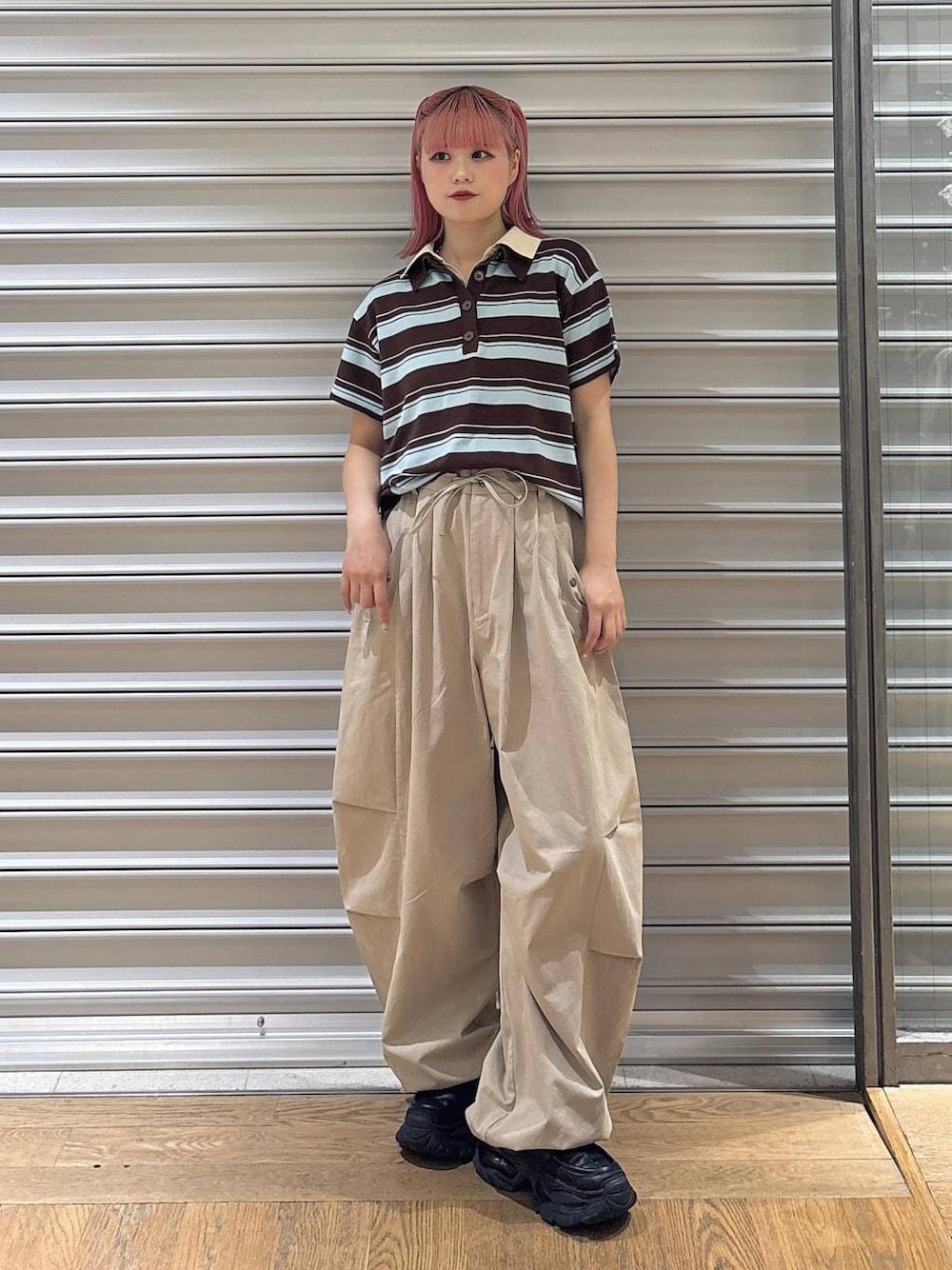 ブラック系のローファー、ベージュ系のその他パンツ、ブラウン系のポロシャツを着用したレディースの夏コーディネートの1枚目の写真