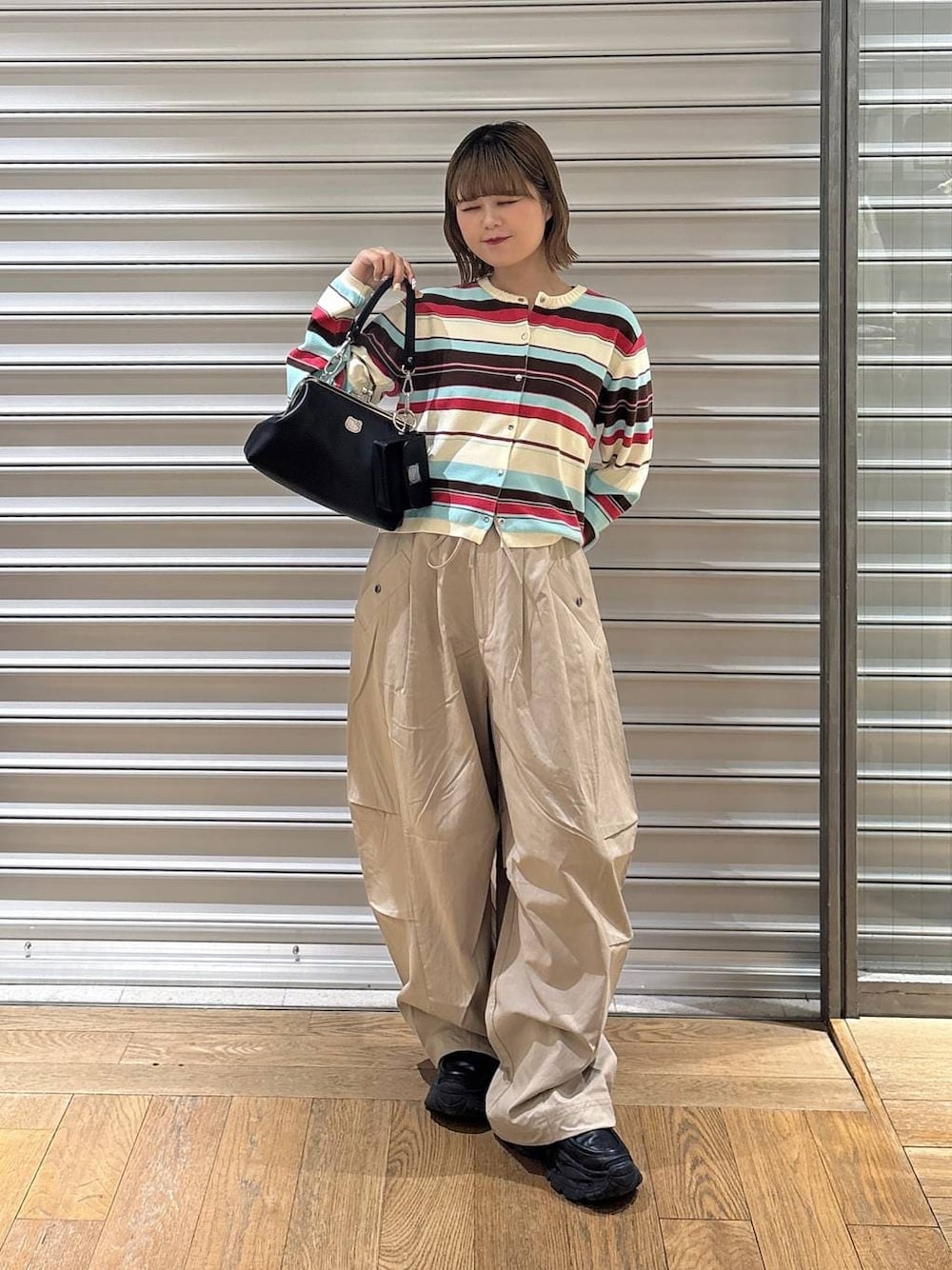 ブラック系のローファー、ブラック系のハンドバッグ、ベージュ系のその他パンツを着用したレディースの春コーディネートの1枚目の写真