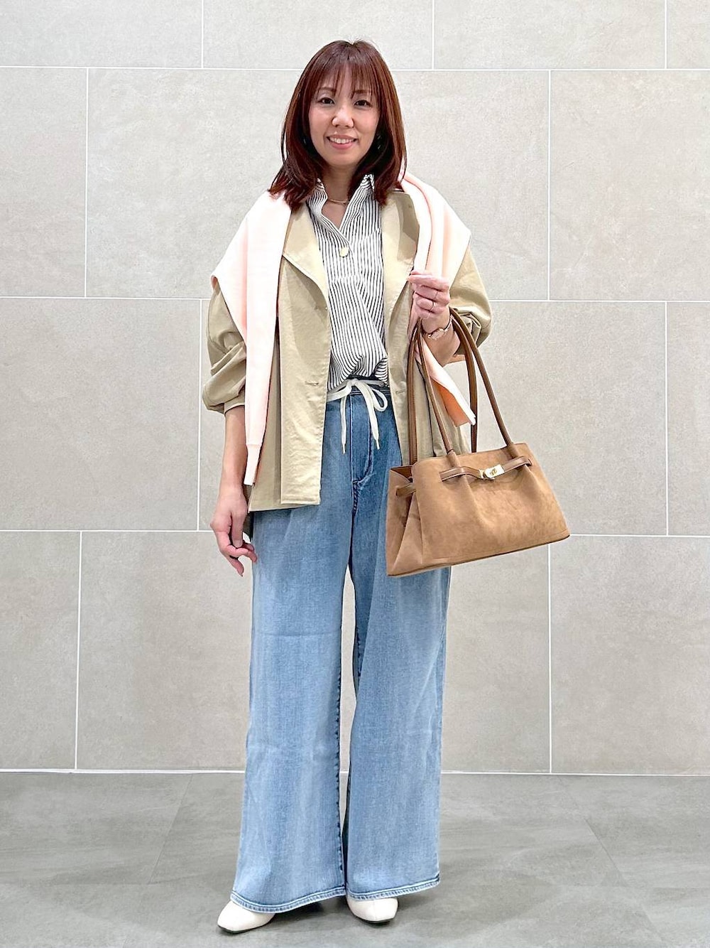 ホワイト系のパンプス、ブルー系のデニムパンツ、イエロー系のハンドバッグを着用したレディースの春コーディネートの1枚目の写真