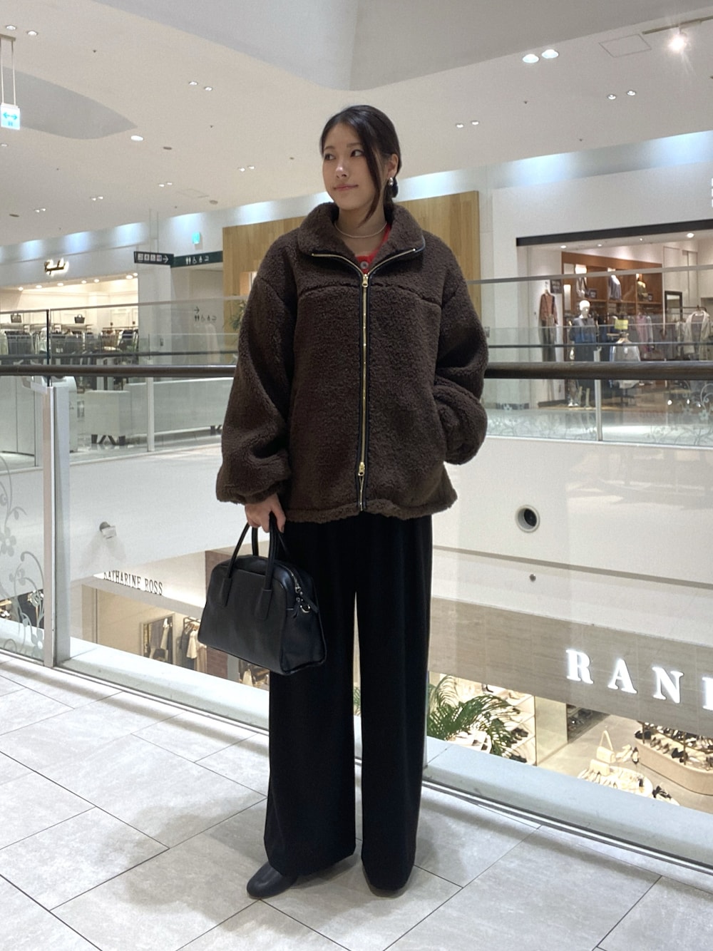 ブラウン系のその他アウター、ブラック系のスラックス、ブラック系のブーツを着用したレディースの秋コーディネートの1枚目の写真