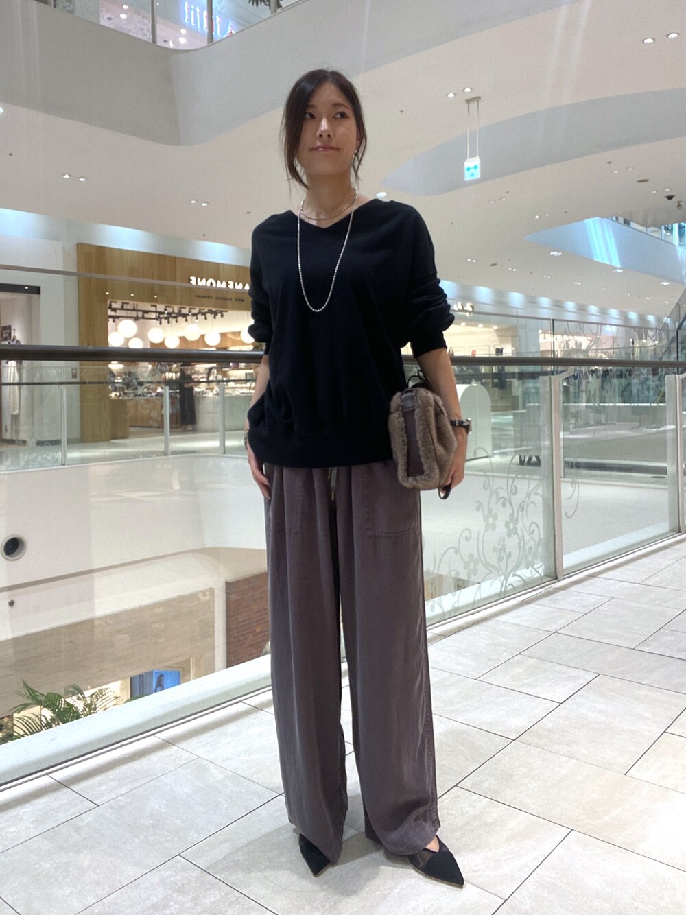 ブラック系のスウェット、グレー系のその他パンツ、ブラウン系のハンドバッグを着用したレディースの夏コーディネートの1枚目の写真