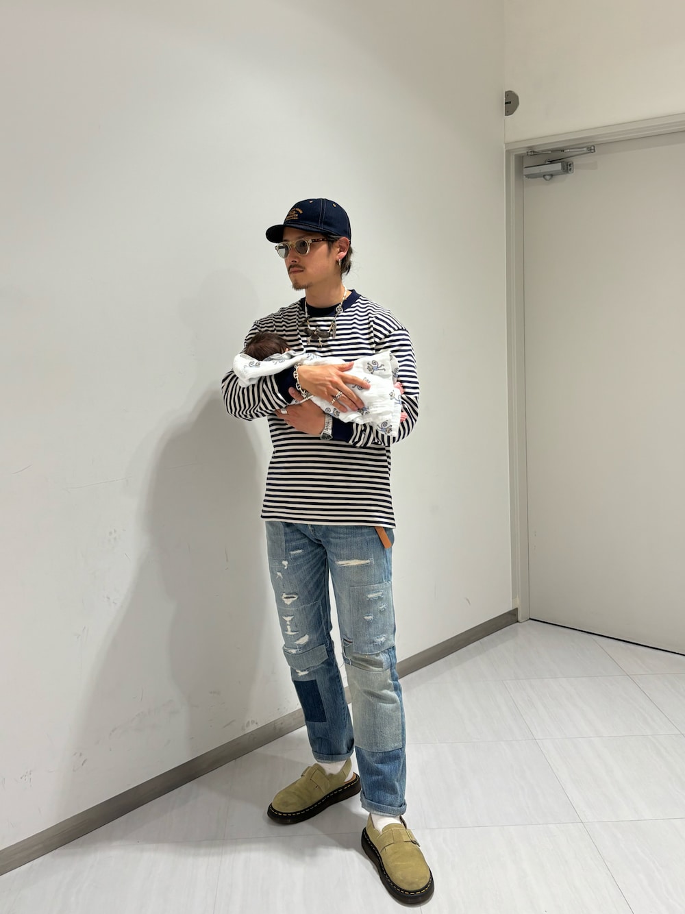 ホワイト系のTシャツ/カットソー、ブルー系のデニムパンツ、ベージュ系のサンダルを着用したメンズの春コーディネートの1枚目の写真