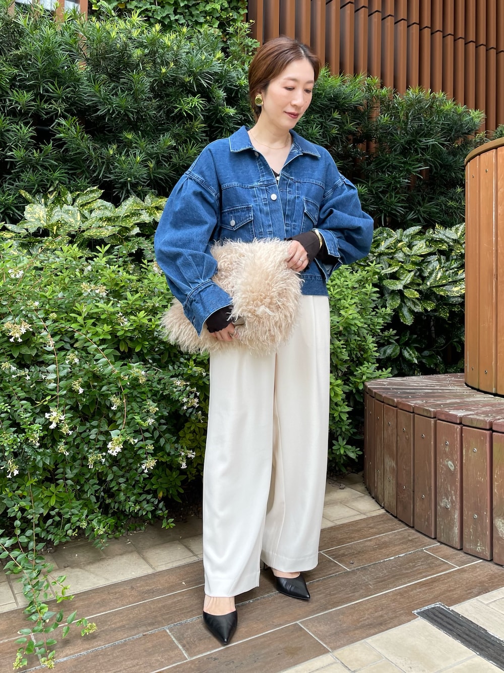 ブルー系のデニムジャケット、ベージュ系のショルダーバッグ、ホワイト系のその他パンツを着用したレディースの秋コーディネートの1枚目の写真