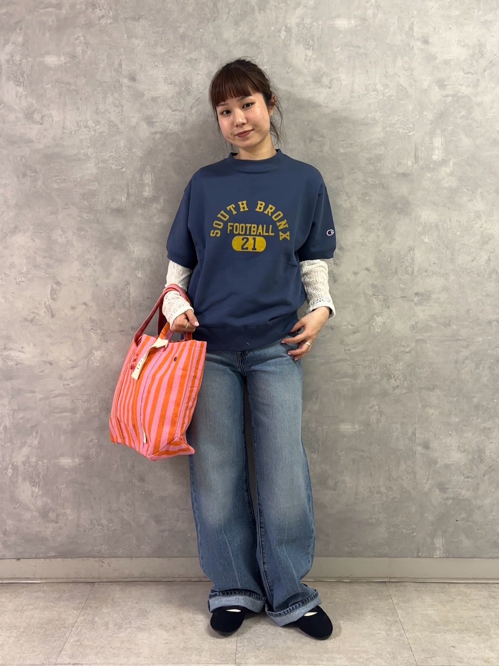 ピンク系のトートバッグ、ブルー系のデニムパンツ、ホワイト系のTシャツ/カットソーを着用したレディースの春コーディネートの1枚目の写真