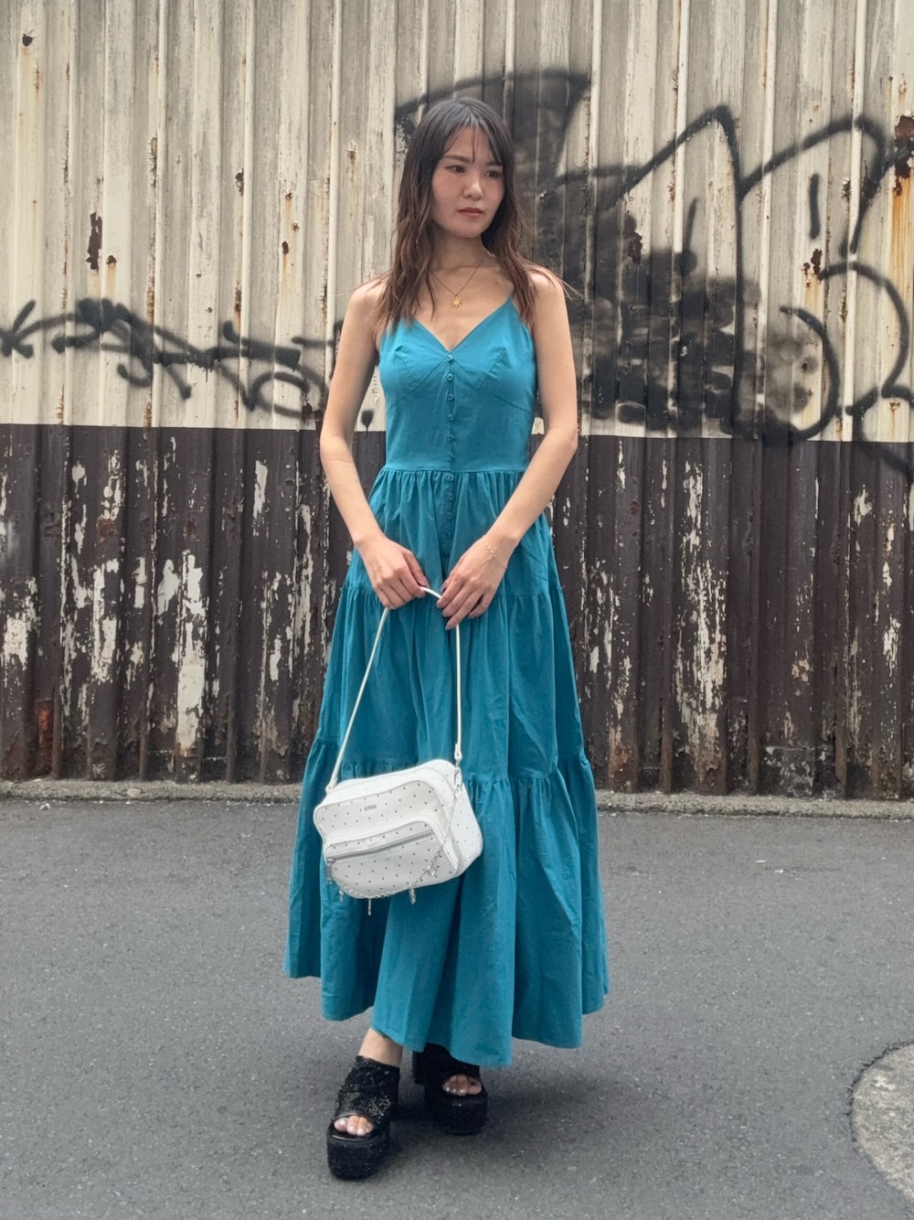 ブルー系のワンピース、イエロー系のハンドバッグ、シルバー系のサンダルを着用したレディースの夏コーディネートの1枚目の写真