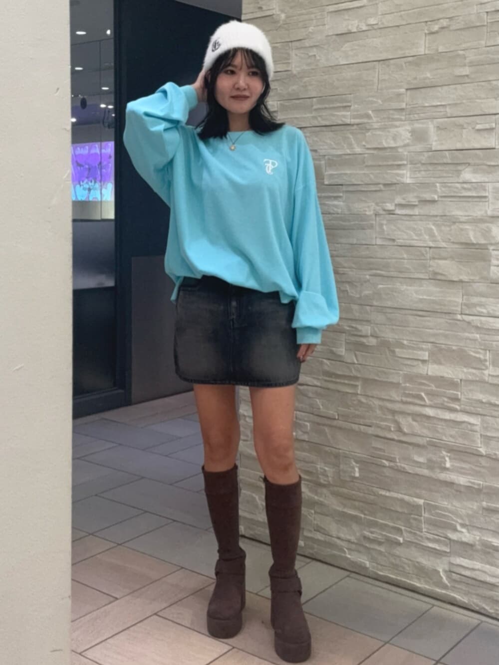 ブルー系のTシャツ/カットソー、ブラック系のデニムスカート、ブラウン系のブーツを着用したレディースの秋コーディネートの1枚目の写真