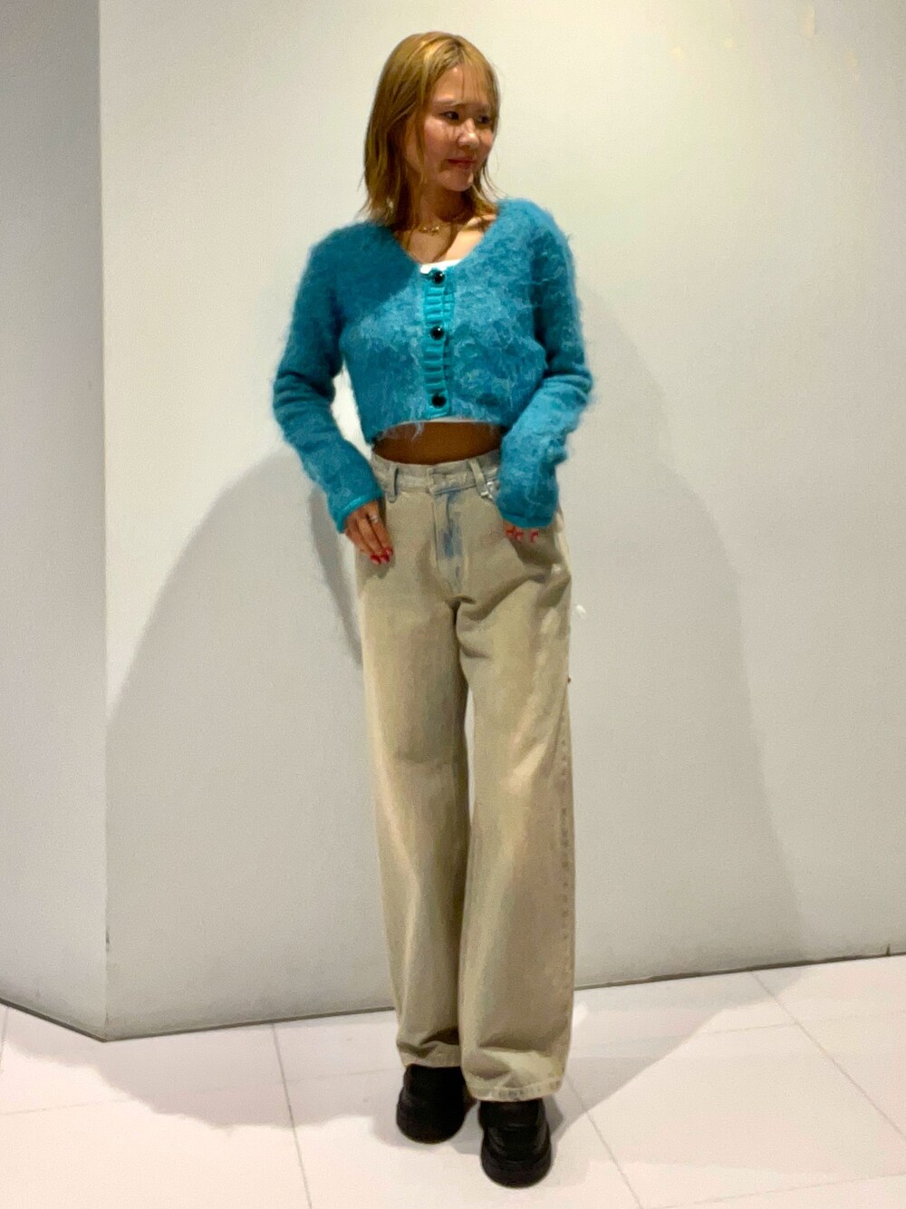 ブルー系のニット/セーター、ブルー系のデニムパンツ、ブラック系のローファーを着用したレディースの秋コーディネートの1枚目の写真