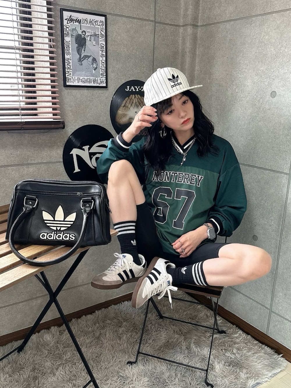 グリーン系のジャージ、ホワイト系のスニーカー、ブラック系のハンドバッグを着用したレディースの秋コーディネートの1枚目の写真