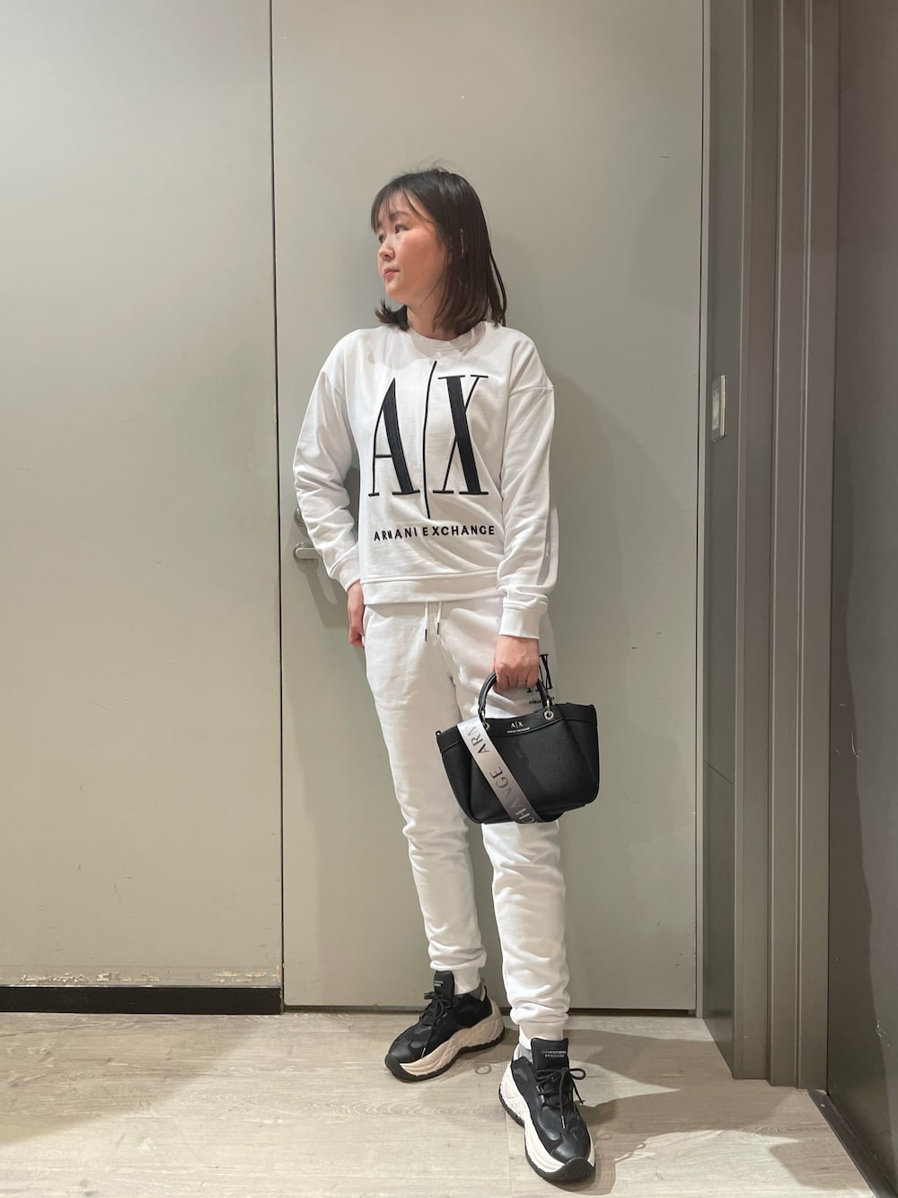 「armaniexchange、ARMANIEXCHANGE、AXchanger、AXchange、オトナ女子、高身長コーデ、スニーカー、ショルダーバッグ、ハンドバッグ、セットアップ、スウェット、ラクチンコーデ、春コーデ、白スウェット、トレーナー」｜「ARMANI EXCHANGEの【A|X アルマーニ エクスチェンジ】A|Xロゴ　ミニハンドバッグ（ハンドバッグ、ブラック系）」を使った、MIさん（レディース・169cm）の冬コーディネートの1枚目の写真