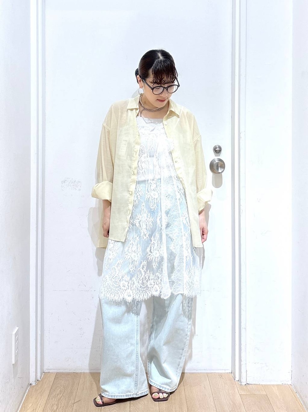 イエロー系のシャツ/ブラウス、ブルー系のデニムパンツ、ブラウン系のサンダルを着用したレディースの夏コーディネートの1枚目の写真